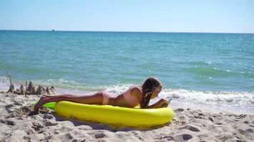 adorable niña en inflable aire colchón en el playa video