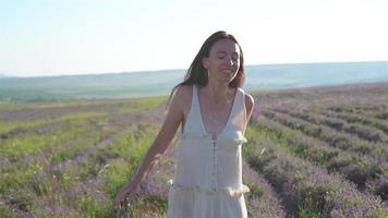 femme dans le champ de fleurs de lavande au coucher du soleil en robe blanche et chapeau video