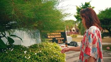 a ásia mulher em pé dentro frente do uma plantar cheio do flores quando ela estava sem descanso e triste dentro uma jardim video