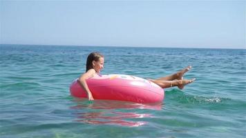 adorable fille sur un matelas pneumatique gonflable dans la mer video