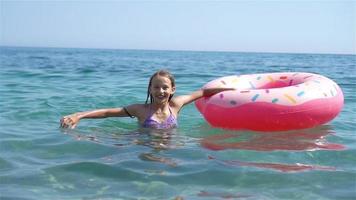 adorable chica en un colchón de aire inflable en el mar video