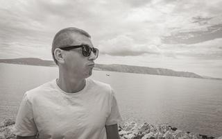 joven modelo masculino con gafas de sol en el paisaje de novi vinodolski croacia. foto