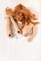 disassembled plastic doll with red hair on board photo