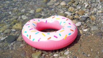 Inflatable colorful Rubber Ring floating on the seashore video