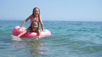 weinig meisjes hebben pret Bij tropisch strand gedurende zomer vakantie spelen samen video