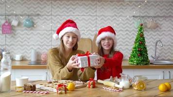 Little girls making Christmas gingerbread house in kitchen video