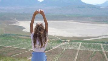 pequeno menina mãos acima perto a lago às a dia Tempo video