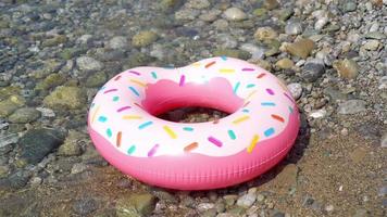 Inflatable colorful Rubber Ring floating on the seashore