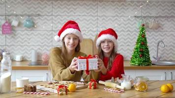 Little girls making Christmas gingerbread house in kitchen video