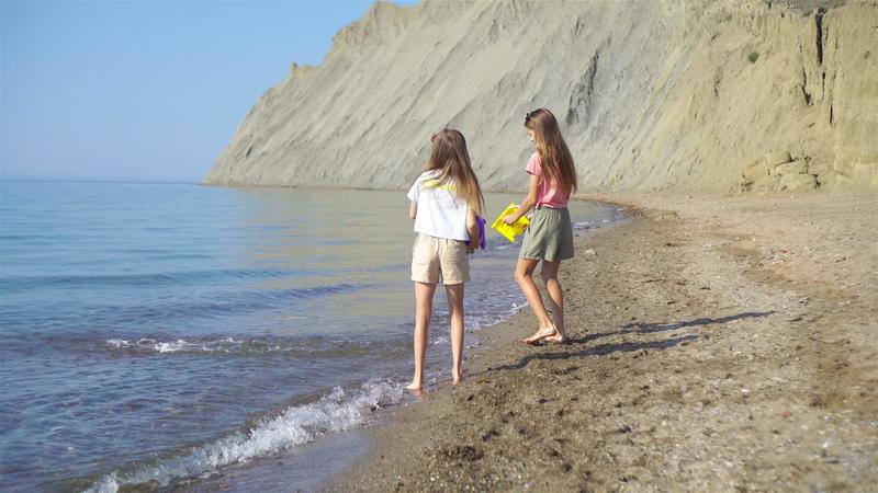 Adorable little girls having fun on the beach 19960023 Stock Video at Vecteezy