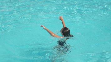 liten förtjusande flicka i utomhus- simning slå samman video