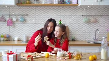 Happy family mother and daughter bake cookies for Christmas