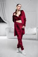 Beautiful brunette dressed in a burgundy velour suit photo