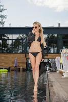 Cute blonde stands near the pool photo