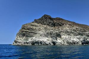 Santorini White Beach with a bright blue sky and the blue sea in Greece. photo