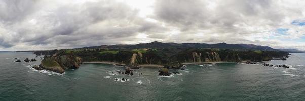 Silence beach, silver-sandy cove backed by a natural rock amphitheatre in Asturias, Spain. photo