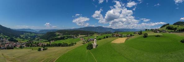 St. Valentin  Kastelruth  Village Church in the summer in the Dolomite Alps. Amazing landscape with small chapel on sunny meadow and Petz peak at Kastelruth commune. Dolomites, South Tyrol, Italy photo