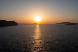 Aerial view of the coast of Santorini, Greece from Akrotiri at sunset. photo