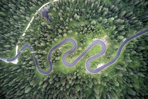 Top aerial view of famous Snake road near Passo Giau in Dolomite Alps. Winding mountains road in lush forest with green spruce in summer time in the Dolomites, Italy photo