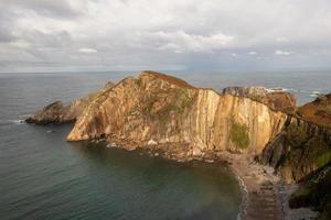 Silence beach, silver-sandy cove backed by a natural rock amphitheatre in Asturias, Spain. photo