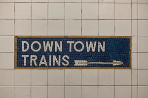 Tiled New York City subway train sign with arrow pointing direction. photo