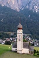 S t. valentin castelruth pueblo Iglesia en el verano en el dolomita Alpes. increíble paisaje con pequeño capilla en soleado prado y mascotas pico a castelruth comuna. dolomitas, sur Tirol, Italia foto