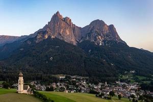 St. Valentin  Kastelruth  Village Church in the summer in the Dolomite Alps. Amazing landscape with small chapel on sunny meadow and Petz peak at Kastelruth commune. Dolomites, South Tyrol, Italy photo