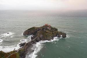 Green rocky mountains and coastline scenery, San Juan de Gaztelugatxe, Spain photo