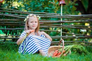 pequeño niña con disfrutado con Fresco zanahorias foto