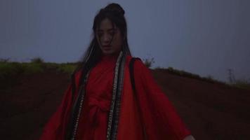 femmes asiatiques exécutant des arts martiaux en bois dans la montagne tout en portant des costumes rouges video