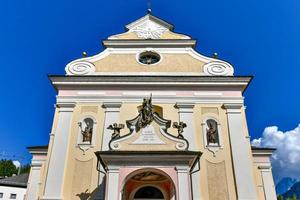 fachada de estilo neoclásico amarillo y naranja de la iglesia parroquial católica de st. Ulrich en Ortisei en los Alpes Dolomitas en Italia foto