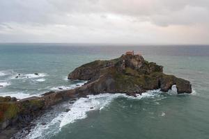 Green rocky mountains and coastline scenery, San Juan de Gaztelugatxe, Spain photo