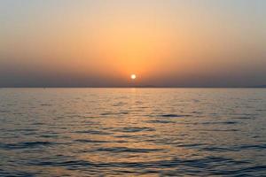 Sunset off of the coast of Oia in the caldera of Santorini, Cyclades islands, Greece, Europe photo