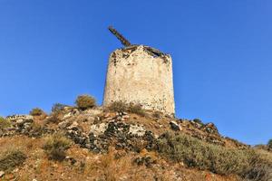 Ruins of old abandoned windmill in Emporio village on the south side of Santorni. Cyclades Islands, Greece. photo