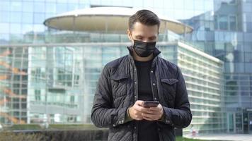 Mens vervelend een masker Aan een achtergrond van een modern gebouw, video