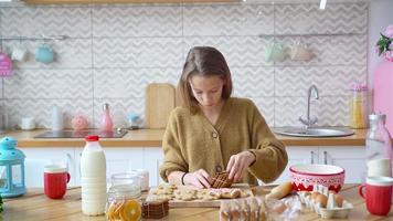 entzückendes kleines mädchen, das weihnachtslebkuchenplätzchen backt video