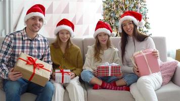 Lycklig ung familj med barn innehav jul presenterar video