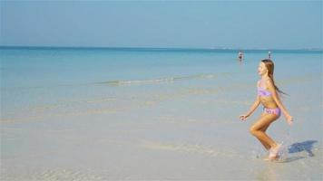 schattig actief meisje op het strand tijdens de zomervakantie video
