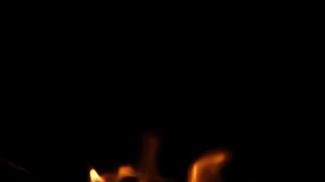 Close-up of burning paper with fire element isolated on black background. flame stream video