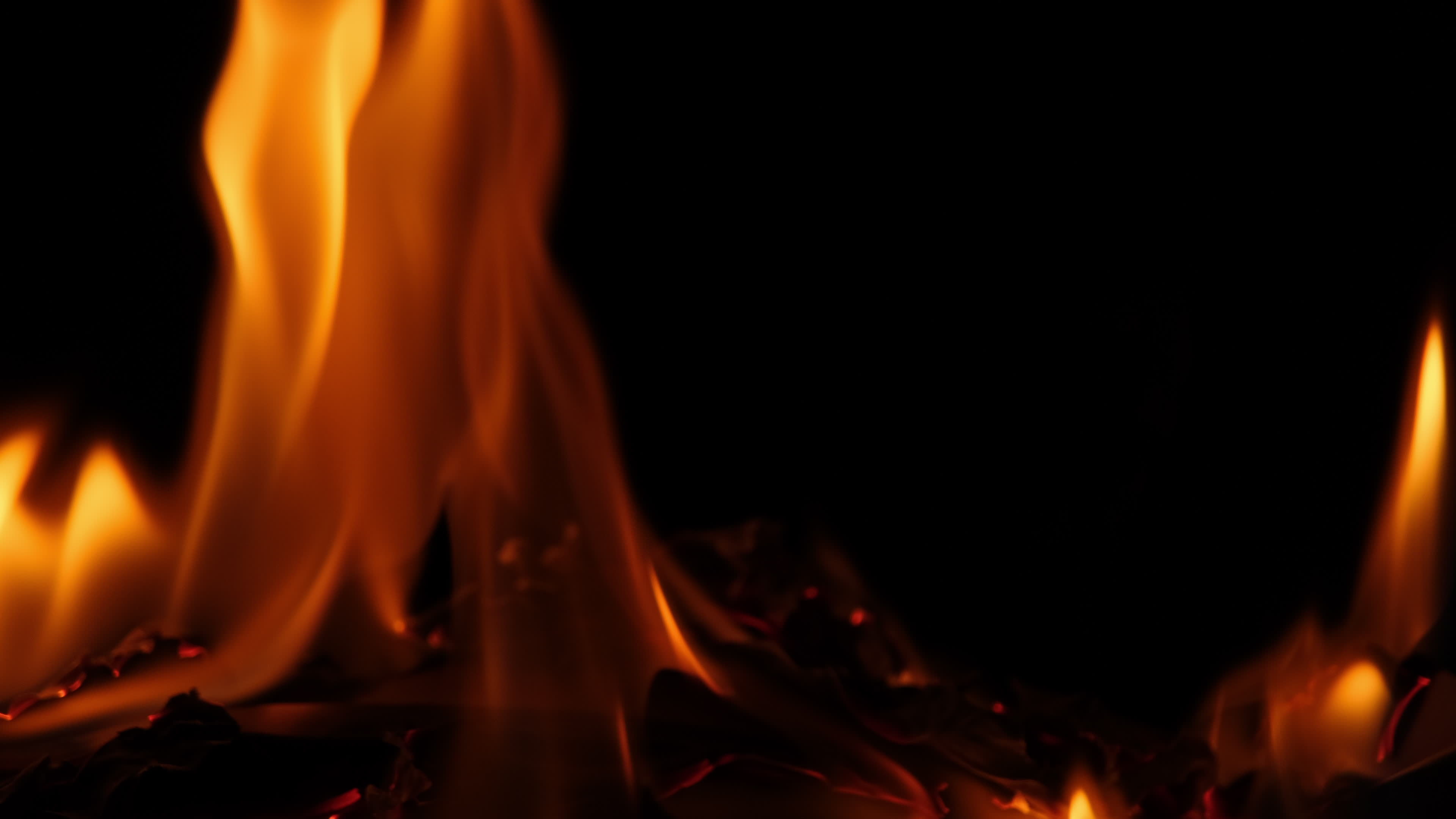 Close-up of burning paper with fire element isolated on black ...