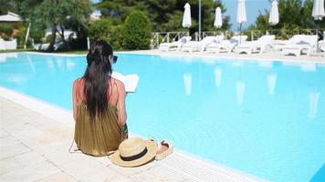 donna rilassante di il piscina nel un' lusso Hotel ricorrere godendo Perfetto spiaggia vacanza vacanza video