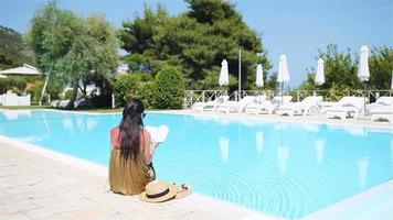 Woman relaxing by the pool in a luxury hotel resort enjoying perfect beach holiday vacation video