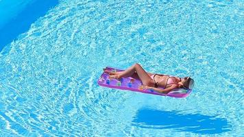 Young woman in bikini air mattress in the big swimming pool video