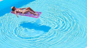 mujer joven en bikini colchón de aire en la gran piscina video