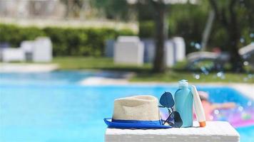 protetor solar, chapéu, oculos de sol perto natação piscina video