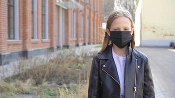 niña con una máscara protege contra el coronavirus y el agarre video