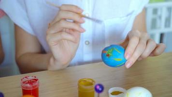 Mother and her little daughter painting eggs. Happy family preparing for Easter. video