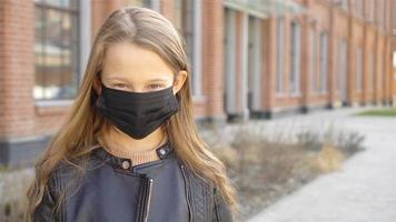 Girl wearing a mask protect against Coronavirus and gripp video