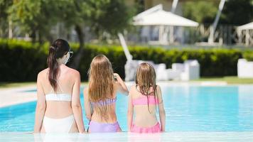 mère et deux enfants profitant des vacances d'été dans une piscine de luxe