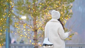 leende ung flicka skridskoåkning på is rink utomhus video